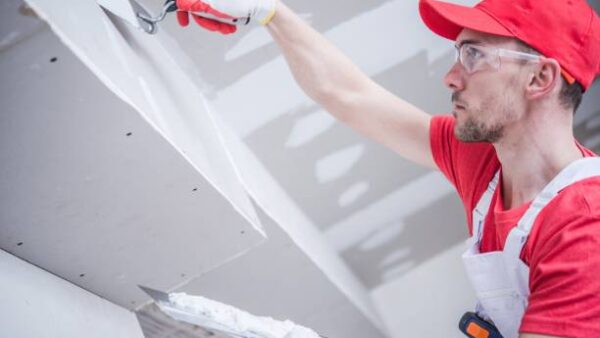 Residential Remodeling Drywall Patching. Caucasian Contractor in His 30s. Construction Theme.